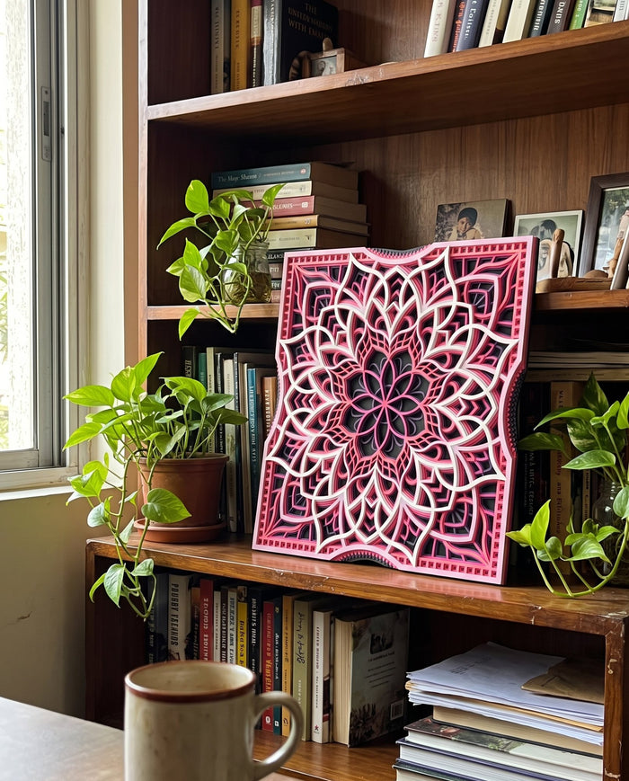 Layered mandala on a bookshelf between plants